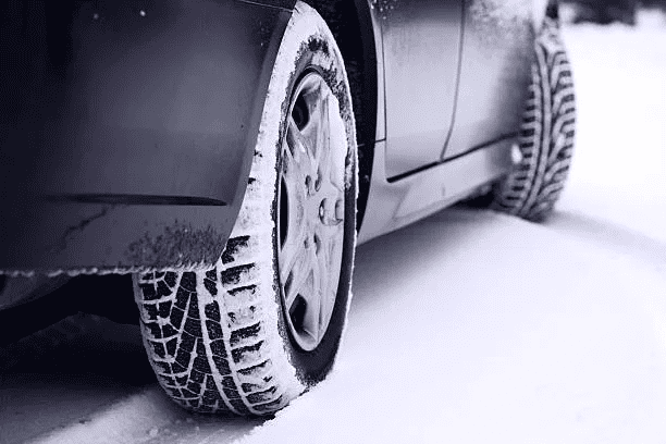 A car with winter tires driving on a snowy road, radial tires, other tires, great tires on wet conditions